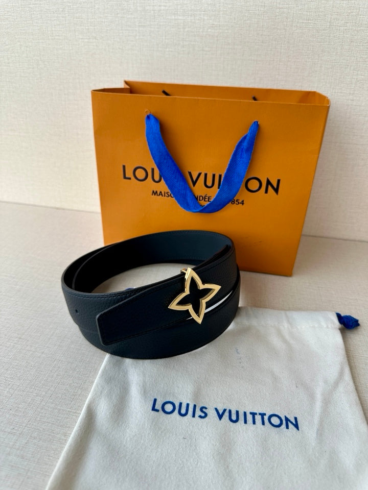 Navy leather belt with gold-toned star emblem buckle on display with gift bag