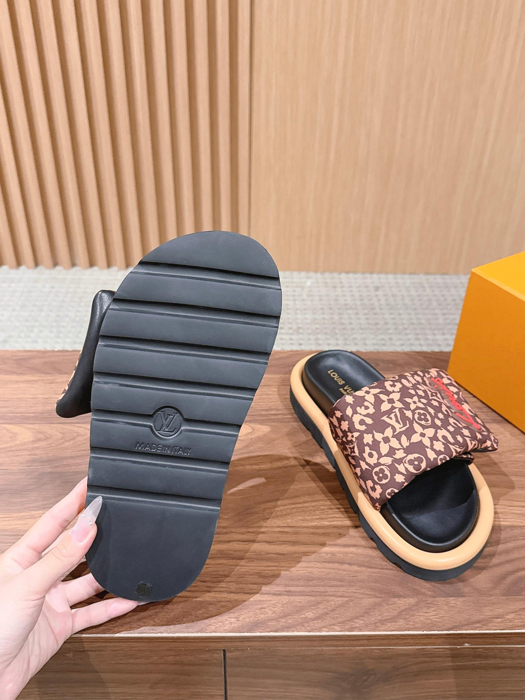 Outsole view of Louis Vuitton slide sandals with patterned upper and beige sole