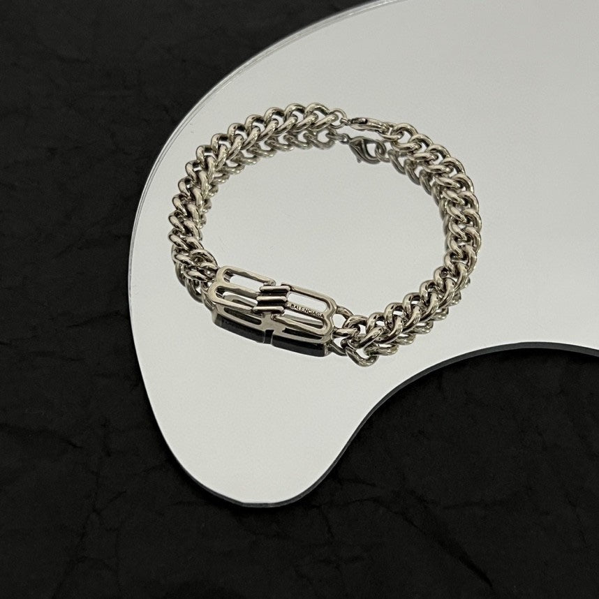 Silver-tone chain bracelet with engraved center links on white tray