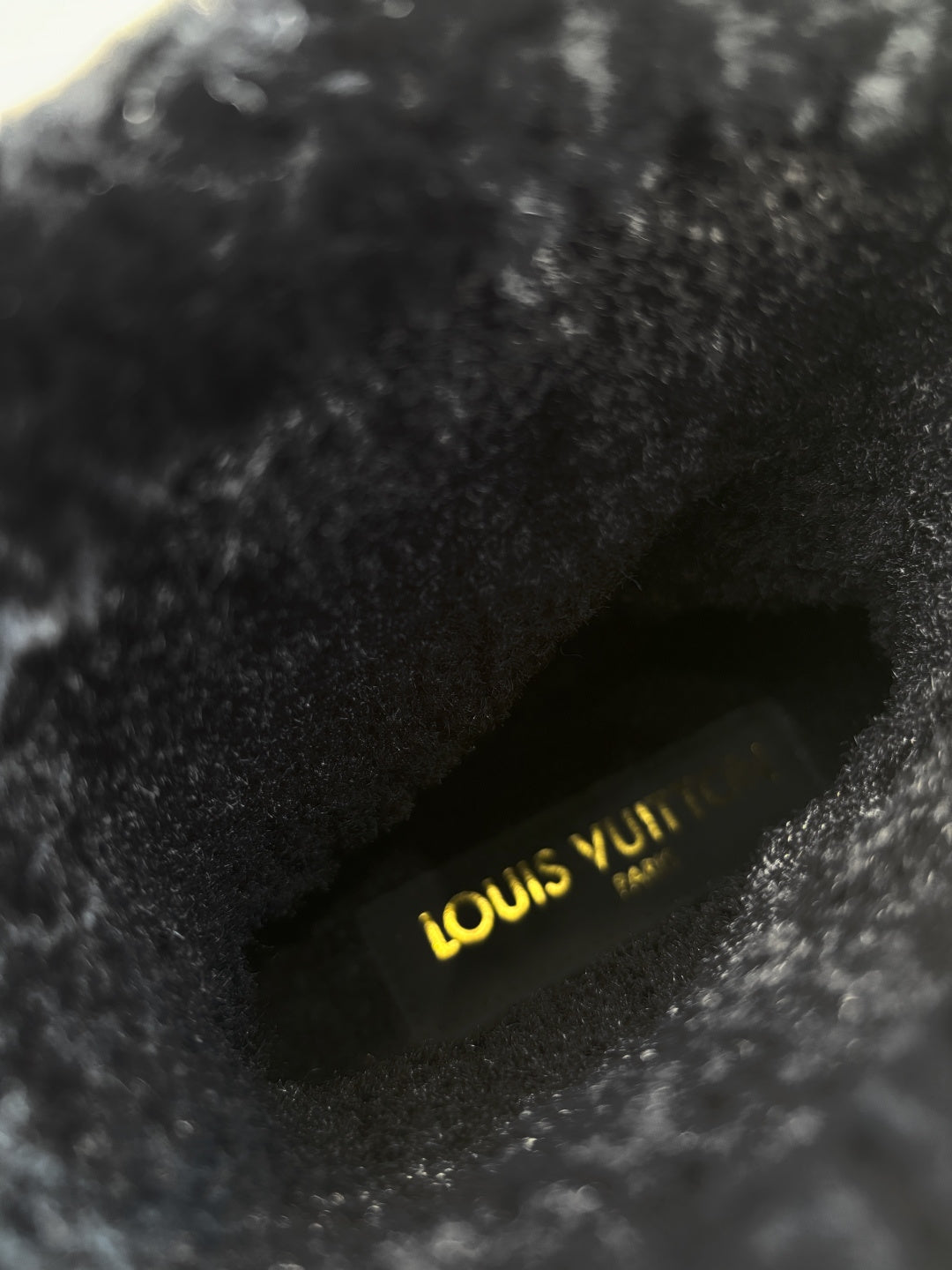 Louis Vuitton logo on black fur-lined insole