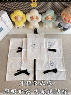 Multiple white Prada gift bags with black ribbon bows, arranged in a stack