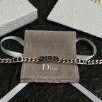 Silver-tone DIOR bracelet on gray pouch with white ribbon ties