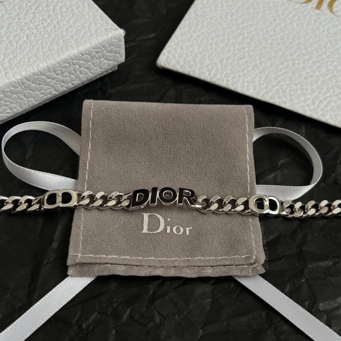 Silver-tone DIOR bracelet on gray pouch with white ribbon ties