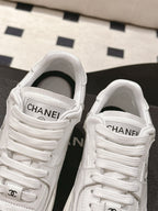 White sneakers close-up of tongue label and lace-up front with side logo emblem