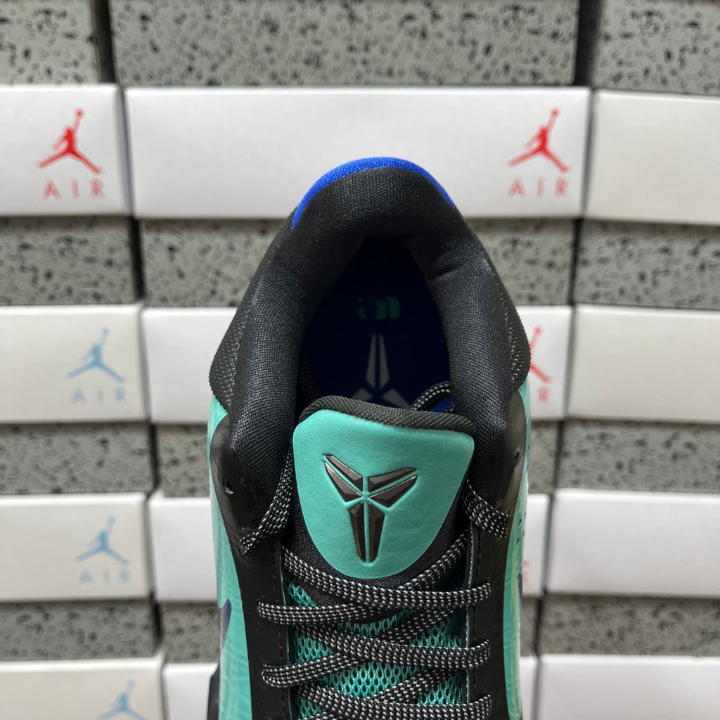Black and teal shoe heel with blue tongue lining and teal emblem patch.