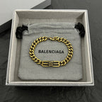 Gold-tone chain bracelet with Balenciaga logo clasp, displayed in box