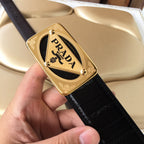 Black leather belt with gold Prada logo buckle and embossed strap pattern