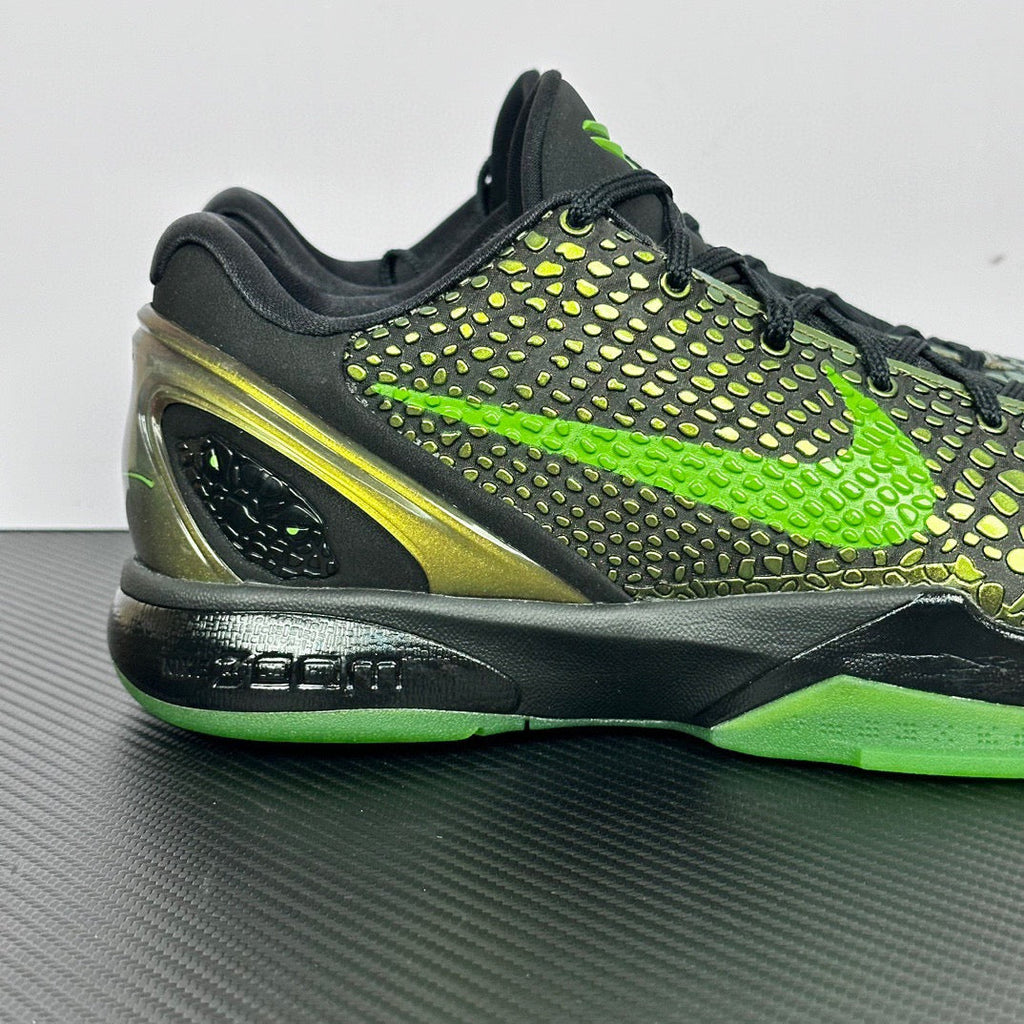 Black and green basketball shoe with textured upper, yellow side stripe, and lime outsole.