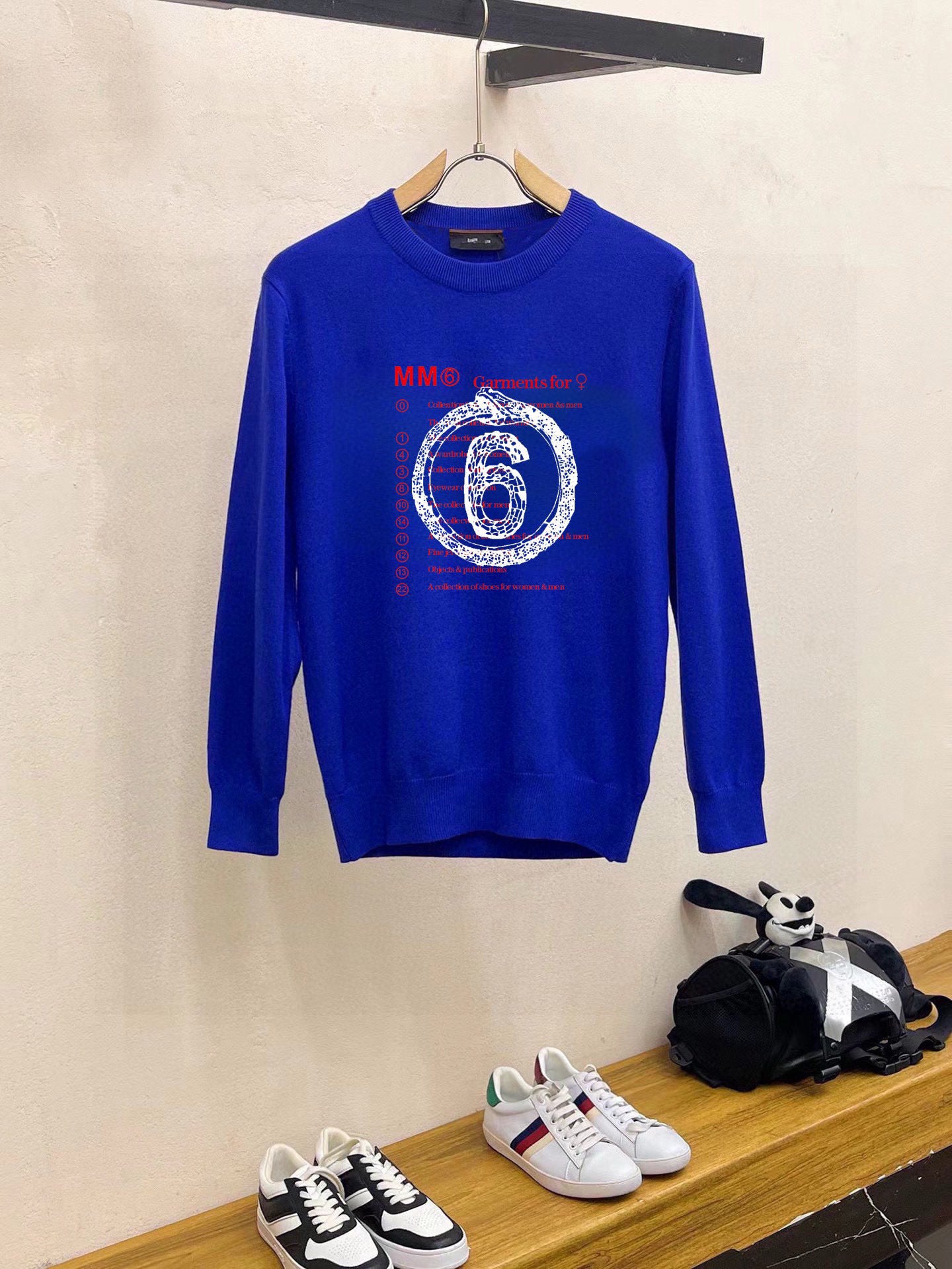 Blue crewneck sweatshirt with long sleeves and “6” graphic print on chest