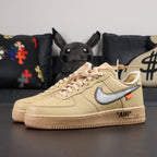 Front view of cream Air Force 1 low-top sneakers with blue Nike swoosh and lace-up