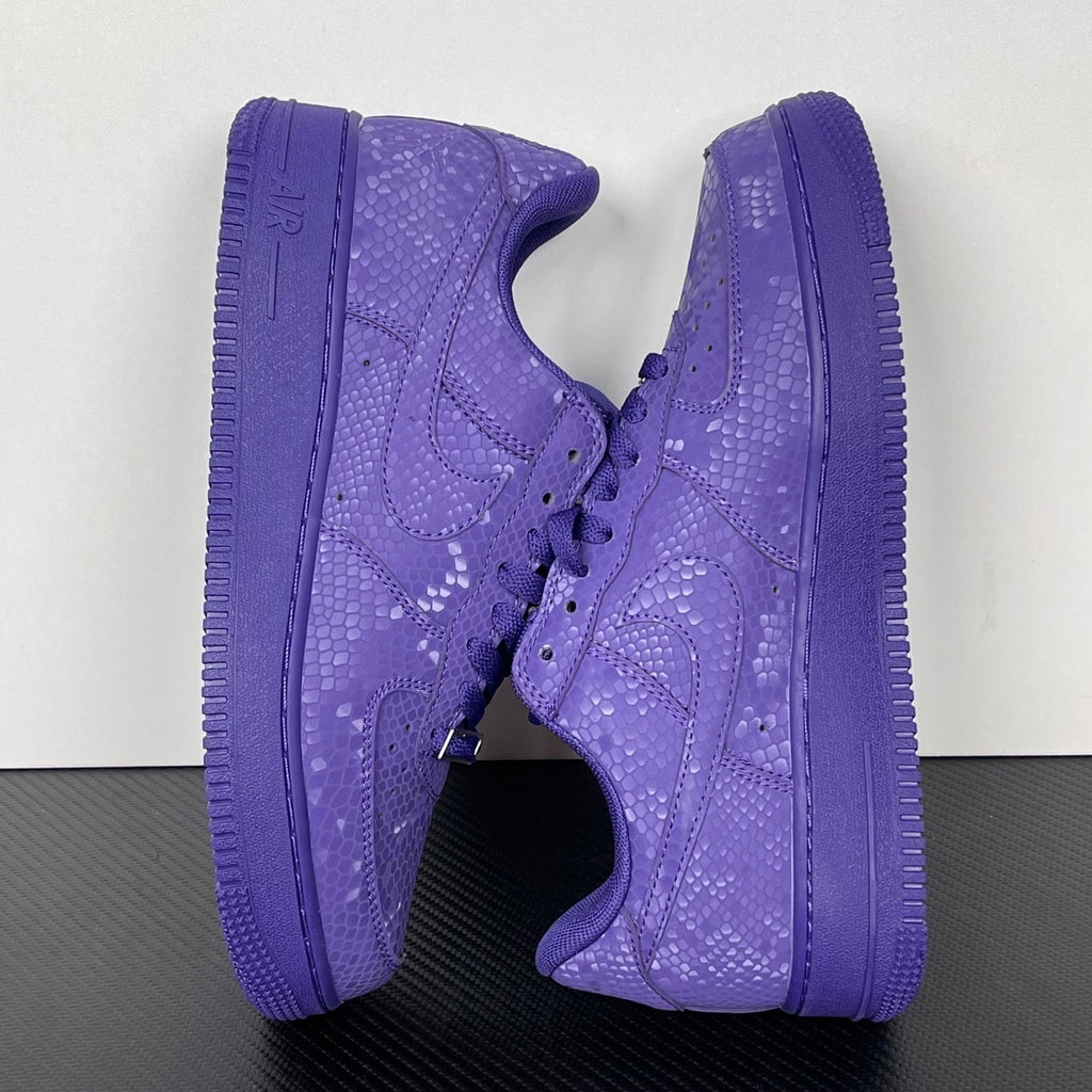 Pair of purple low-top sneakers shown from the side with lace-up closure