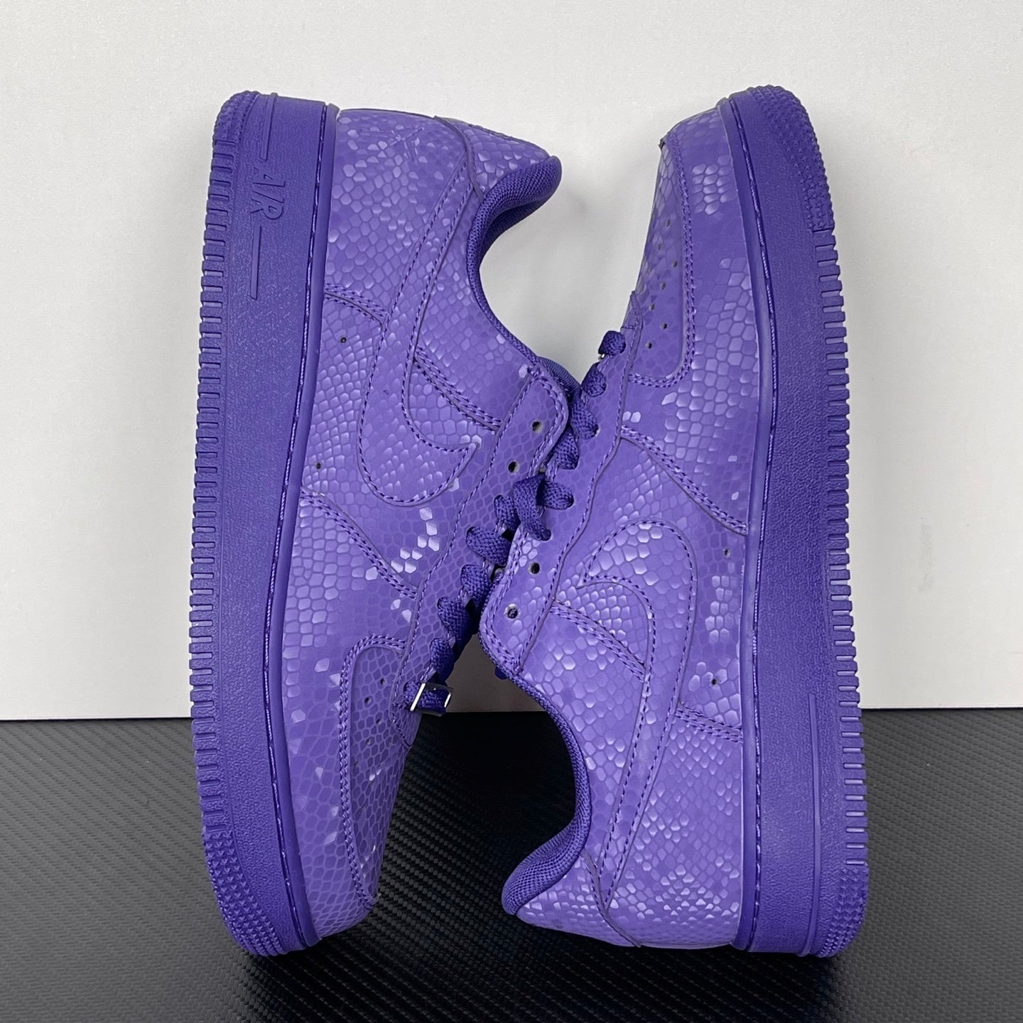 Pair of purple low-top sneakers shown from the side with lace-up closure