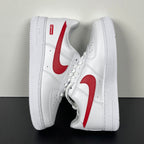 White low-top sneakers with red swoosh and Supreme heel patch, angled side view.