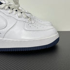 White Nike Air Force 1 low-top sneaker with perforated toe and navy outsole edge