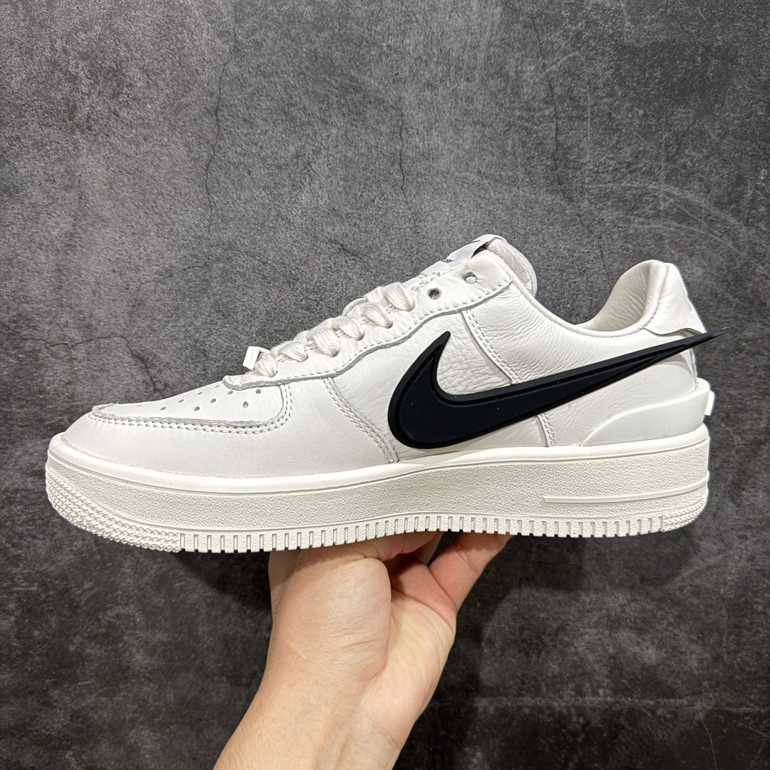 White leather low-top sneaker with black swoosh and thick rubber sole