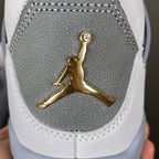 Gold Jumpman logo on gray sneaker panel with white stitching