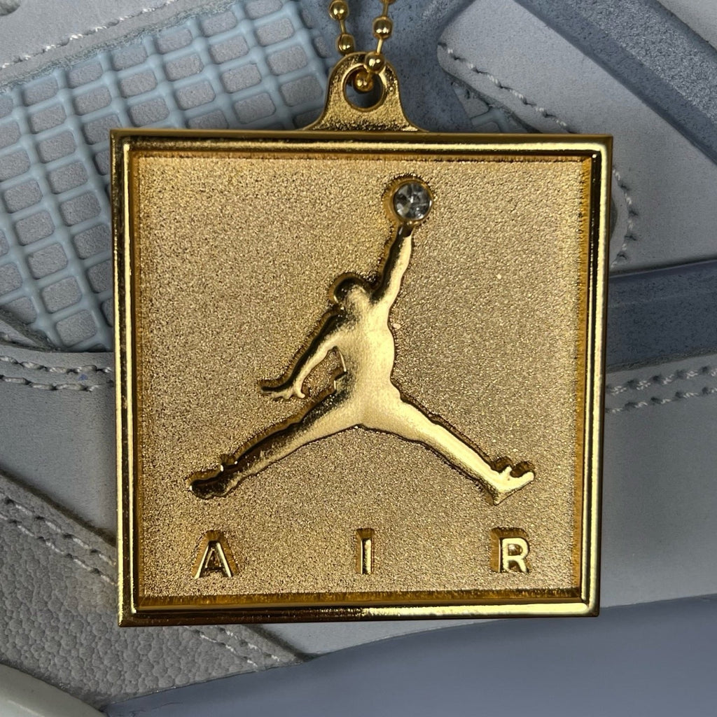 Gold square Jumpman charm on light blue Air Jordan 4 side strap