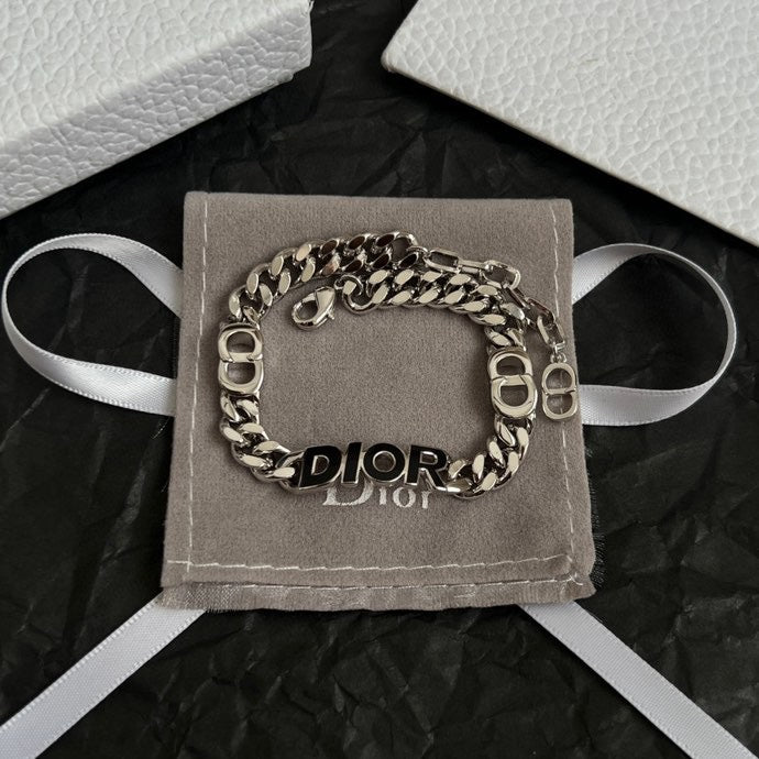 Silver-tone DIOR charm bracelet on gray pouch with white ribbon ties