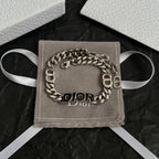 Silver-tone DIOR charm bracelet on gray pouch with white ribbon ties