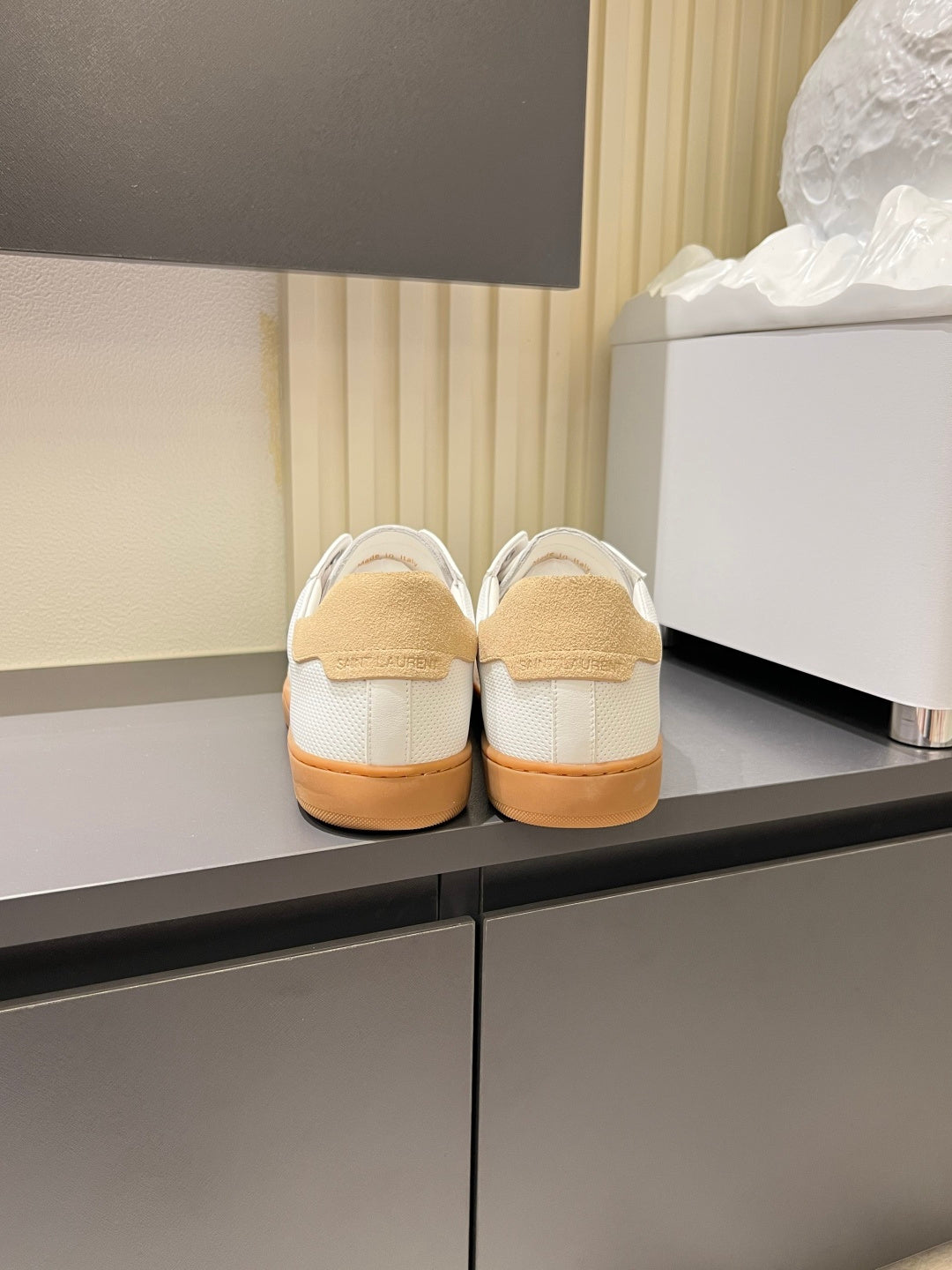 Unisex sneaker rear view, white uppers with tan heel panels and gum soles