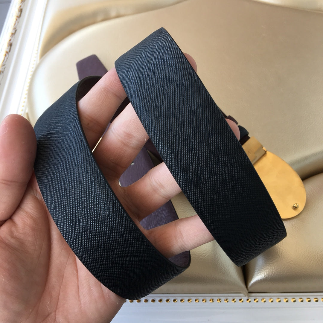Prada belt strap end with gold buckle; dark textured leather and brown underside.
