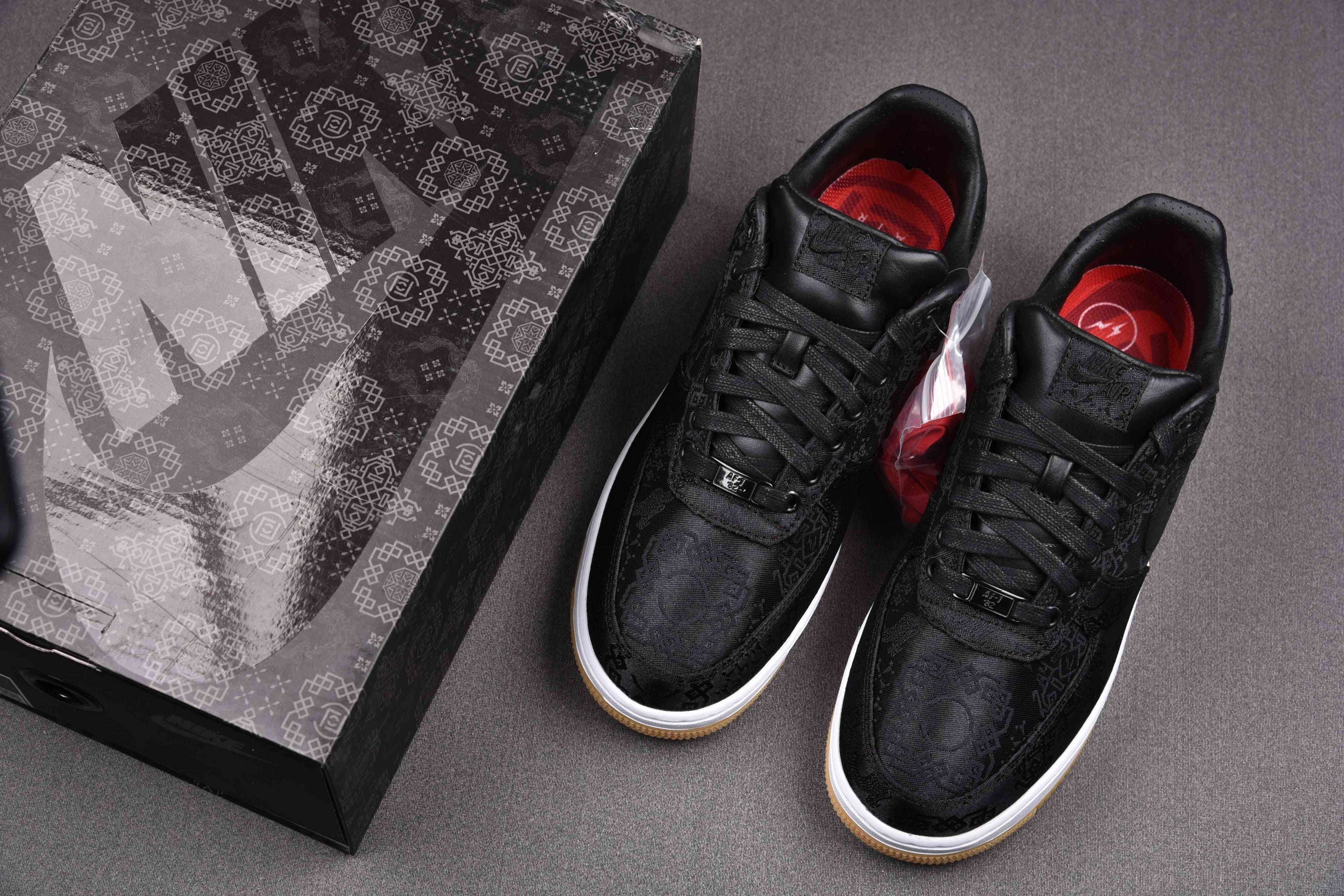 Black low-top sneakers with white midsoles and red-lined interior
