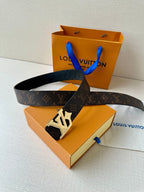 Louis Vuitton monogram belt with dark strap and gold-tone LV buckle, resting