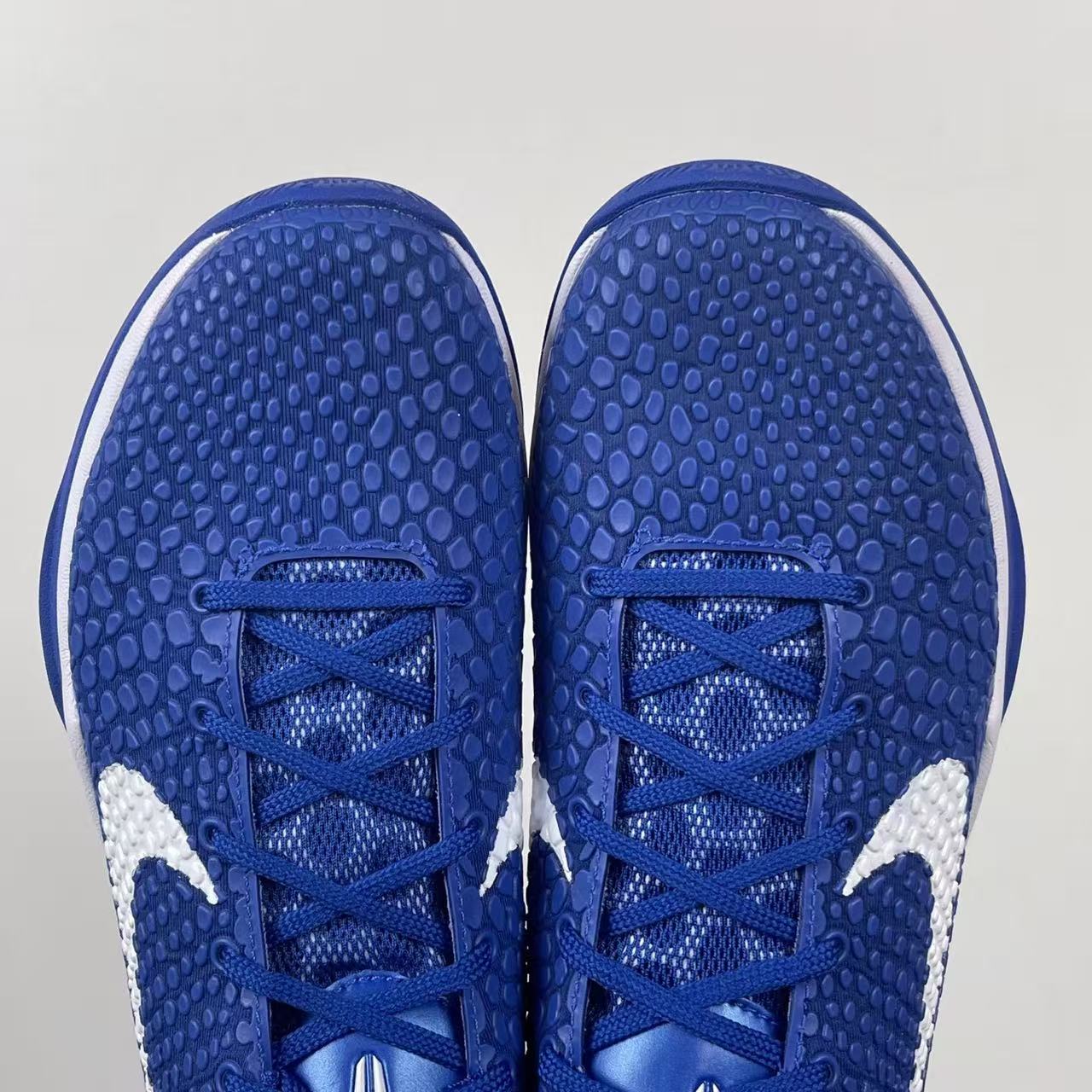 Blue Nike basketball sneaker toe view with blue laces and white side panels