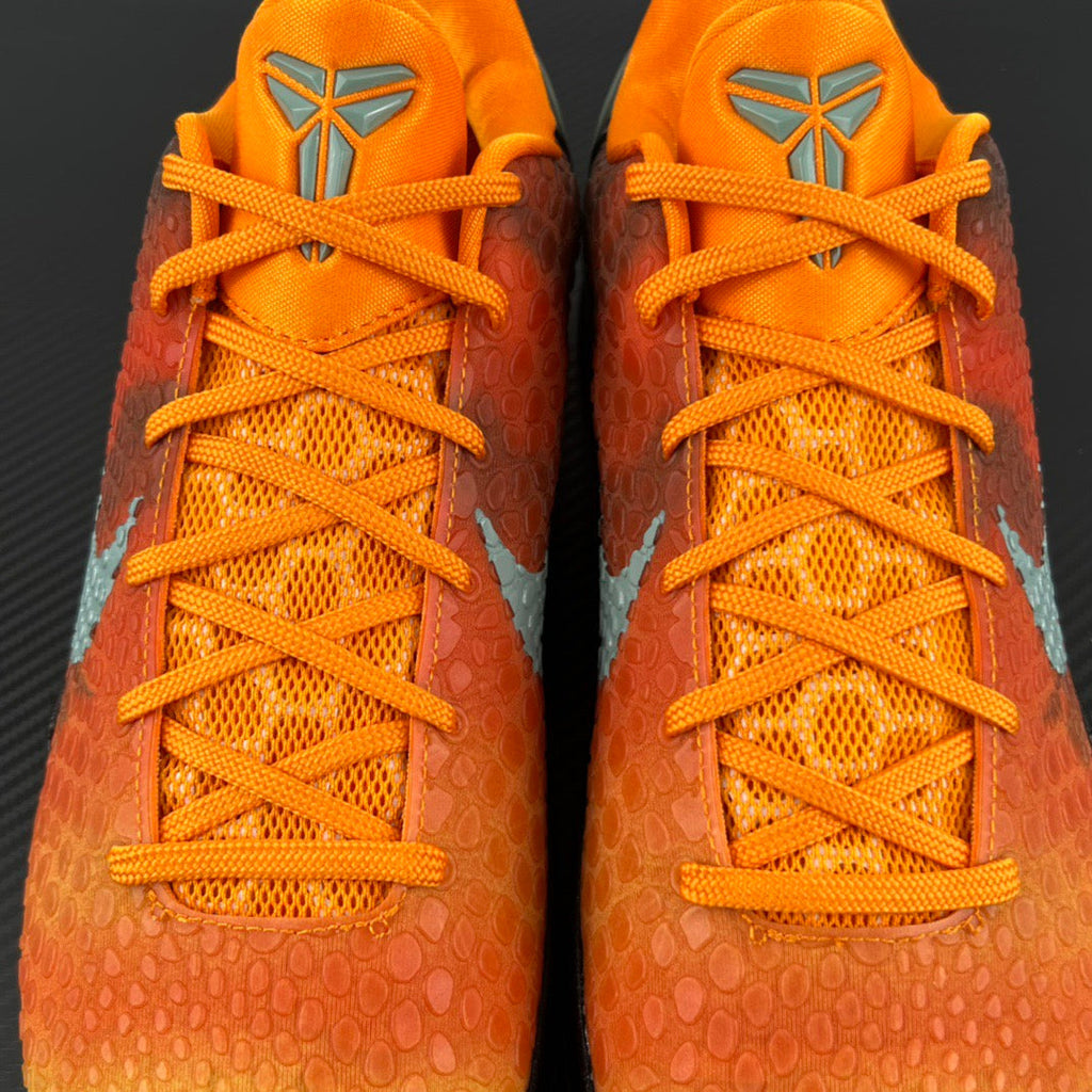 Orange lace-up athletic sneakers with mesh panels and gray side emblems