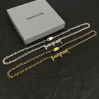 Balenciaga gold chain necklace set with pendants and clasp charms on display