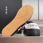 Black leather sneaker outsole with tan patterned tread and AMIRI heel logo