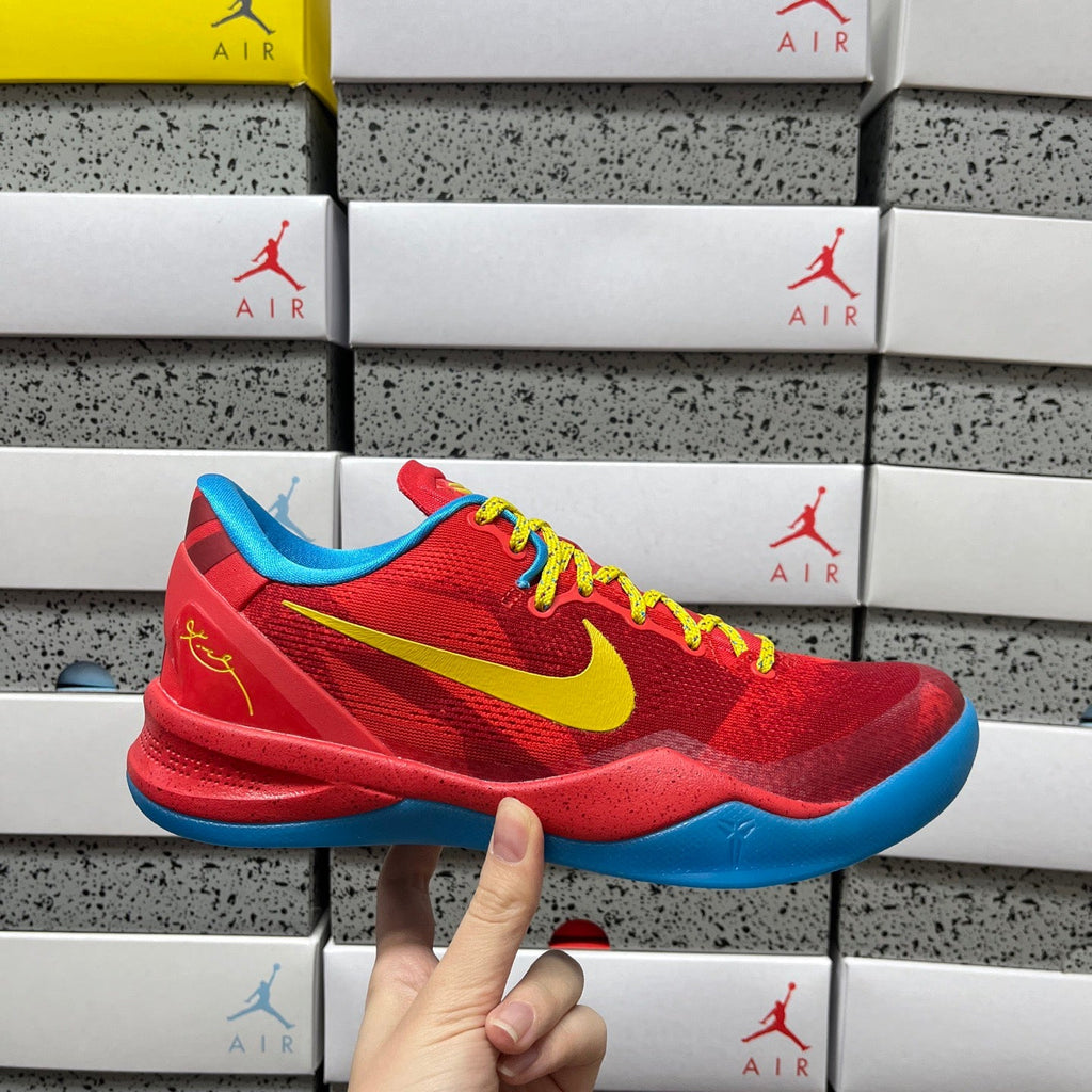 Red basketball shoe with yellow swoosh, blue sole, and yellow-green laces.