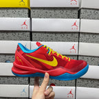 Red basketball shoe with yellow swoosh, blue sole, and yellow-green laces.