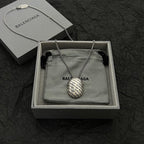 Silver-tone chain necklace with round logo pendant, shown in gift box