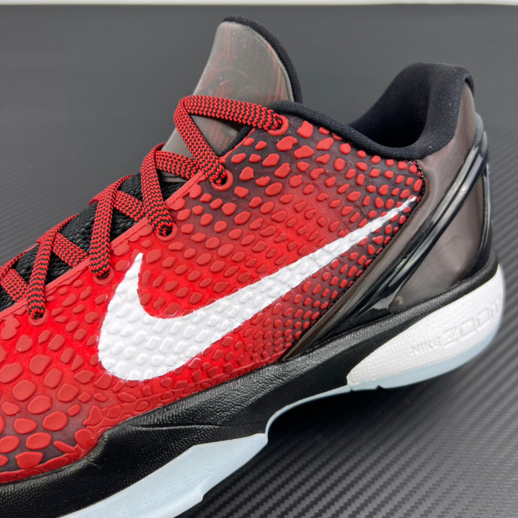 Close-up side view of red and black basketball sneaker with white swoosh and sole.