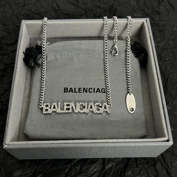 Silver Balenciaga logo pendant necklace with small charm detail in box