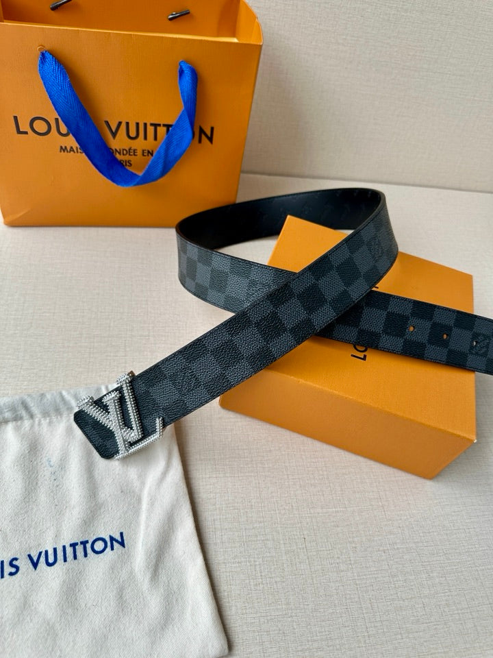 Belt angled on display: dark checkered strap with large silver-toned LV buckle