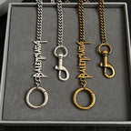 Balenciaga keychain set: silver and gold tone logo charms in tray