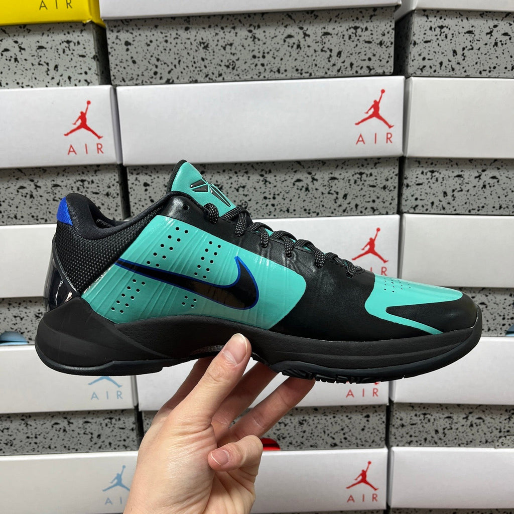 Black and teal basketball shoe in three-quarter view with blue swoosh and laces.