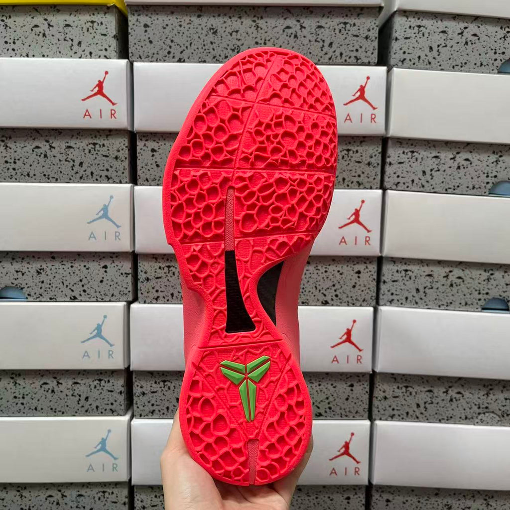 Red rubber outsole with textured tread and green bow logo at heel