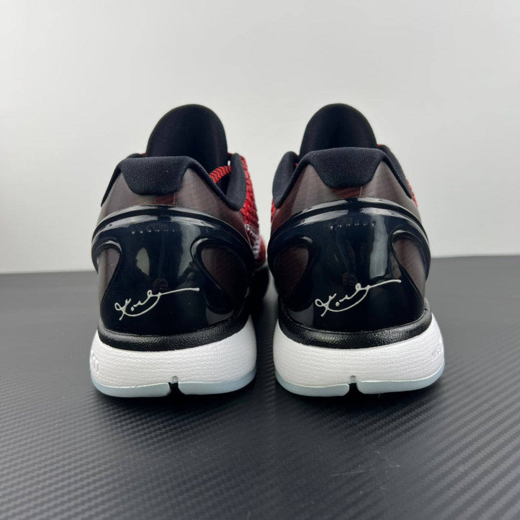 Back view of red and black basketball shoes with white midsoles and heel details.