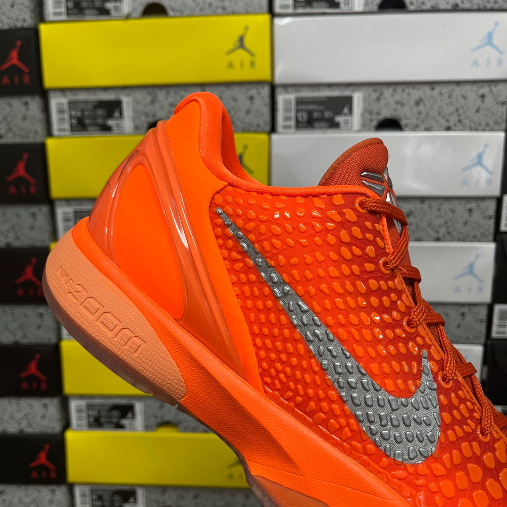 Orange sneaker with gray swoosh and glossy heel panel