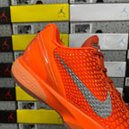 Orange sneaker with gray swoosh and glossy heel panel