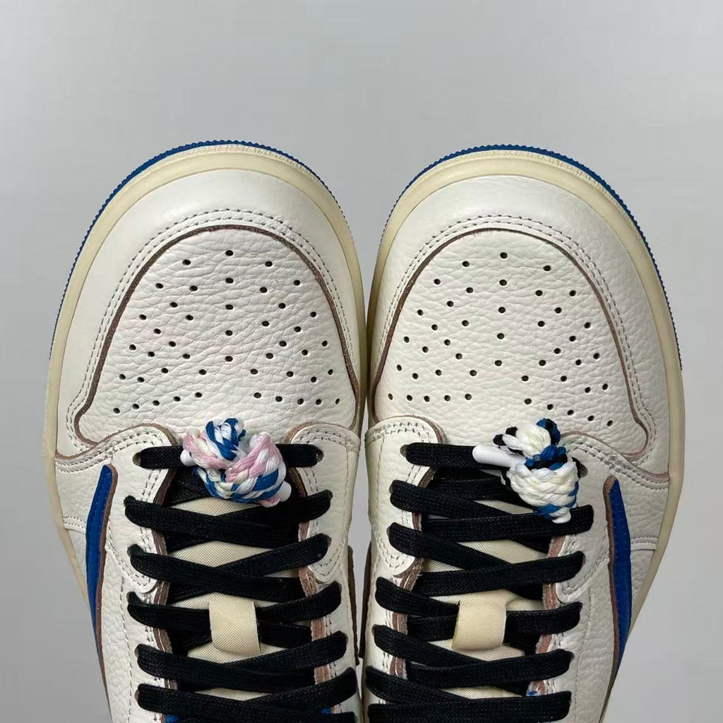 Front view of white sneakers with perforated toe box and black lace system