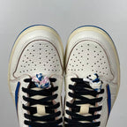 Front view of white sneakers with perforated toe box and black lace system