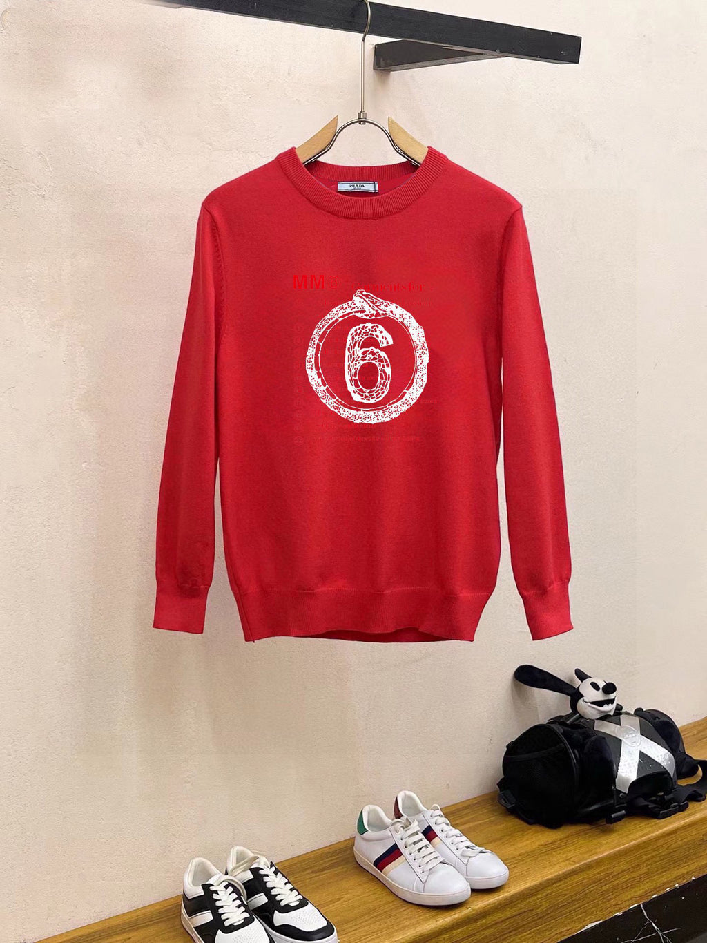 Red crewneck sweatshirt with long sleeves and “6” graphic print on chest