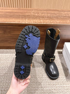 Boot outsole tread with blue patterned grip, beside a black mid-calf boot.
