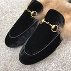 Black velvet loafers showing gold-tone chain ring detail and beige fur cuff