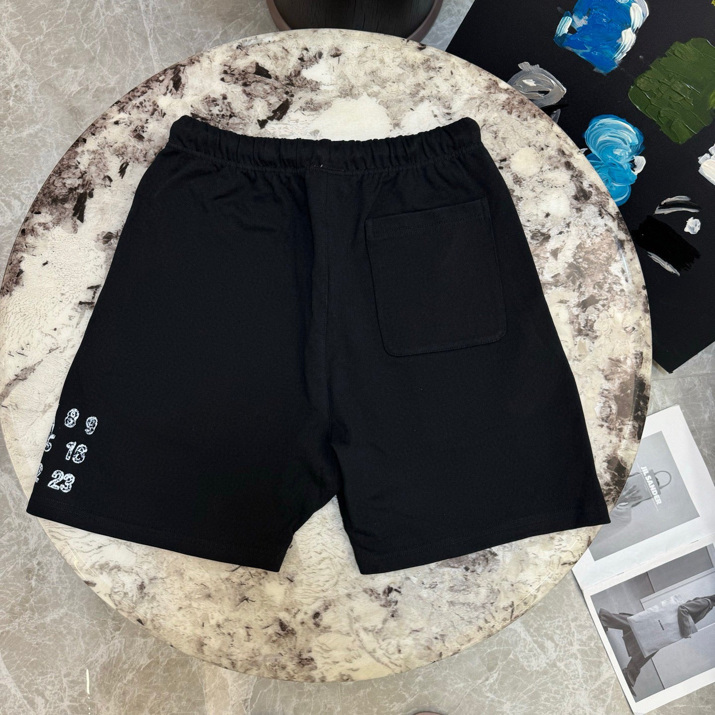 Black drawstring shorts with side pocket and small left number print
