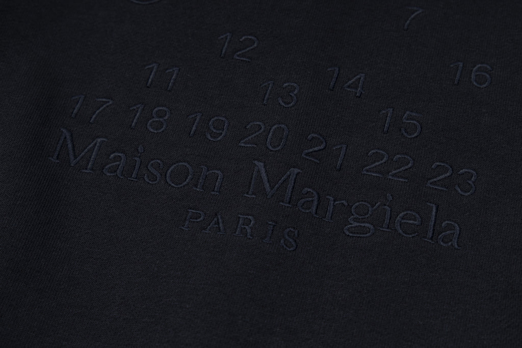 Dark navy fabric with embossed Maison Margiela Paris logo lettering